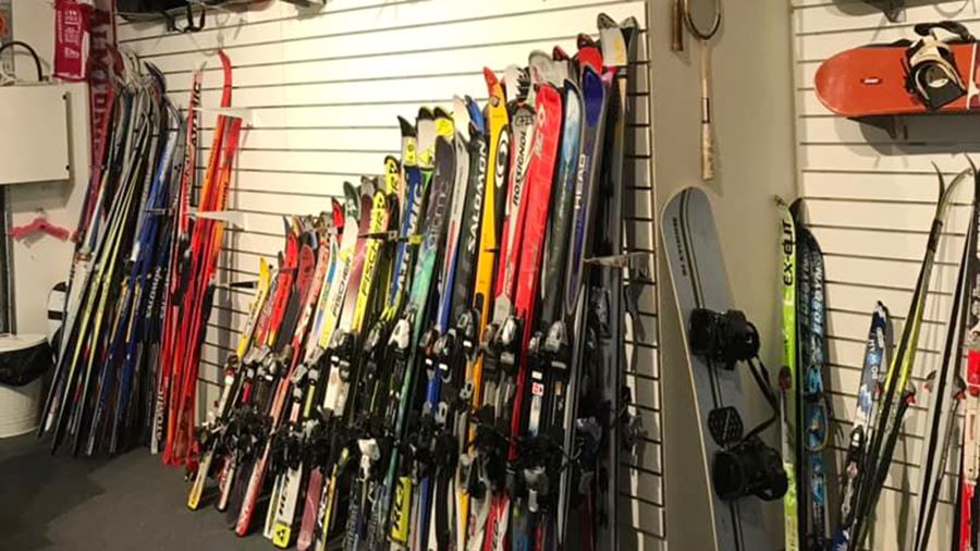 Skidor och snowboard lutade mot en vägg