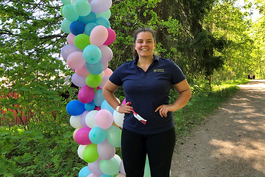 en kvinna i kommunens kläder bredvid ballonger i skogsmiljö