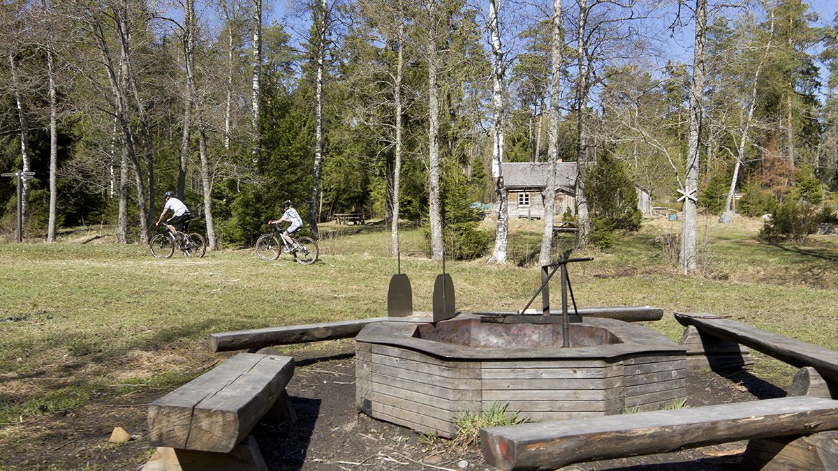 Grillplatsen vid Lunsentorpet. Två personer cyklar i bakgrunden.