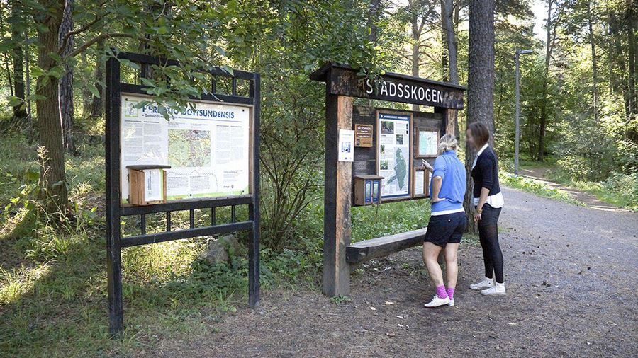 Två tjejer tittar på en karta i Stadsskogens naturreservat.