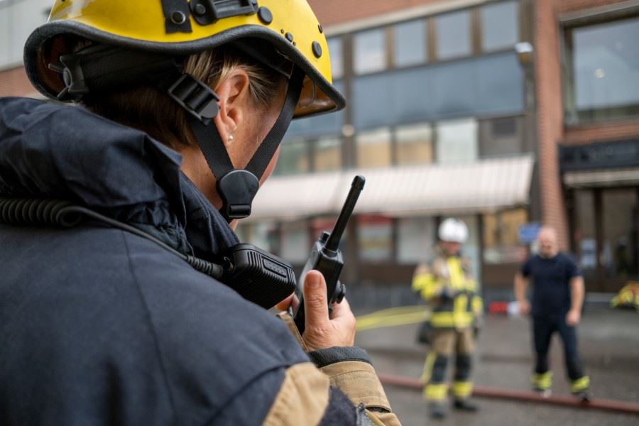 Brandman bakifrån utanför en byggnad